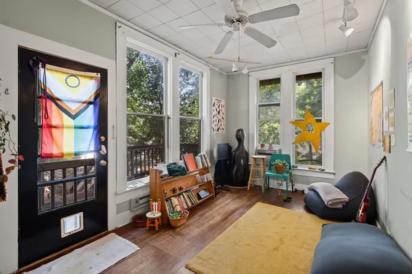 a living room with furniture a flat screen tv and a large window