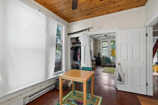a room with wooden floor table and chairs