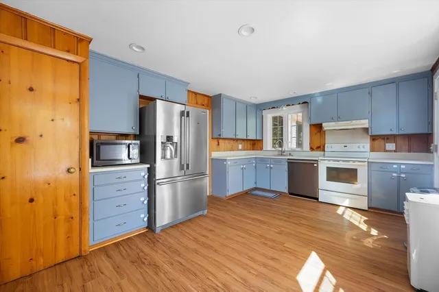 a kitchen with stainless steel appliances a refrigerator and wooden cabinets