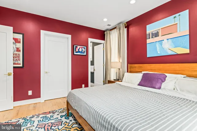 a bedroom with a bed and a painting on the wall