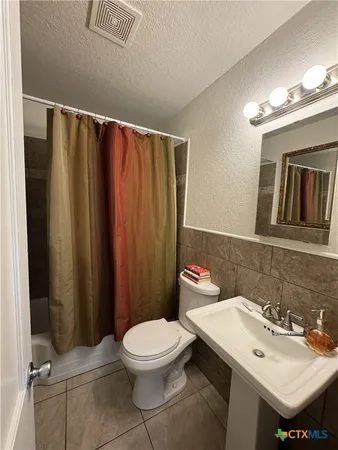 a bathroom with a sink a toilet and a mirror