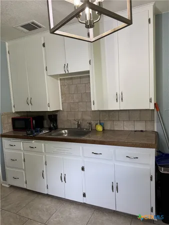 a kitchen with white cabinets and white appliances
