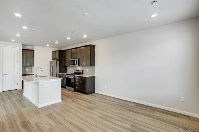 a kitchen with a sink a stove refrigerator and cabinets