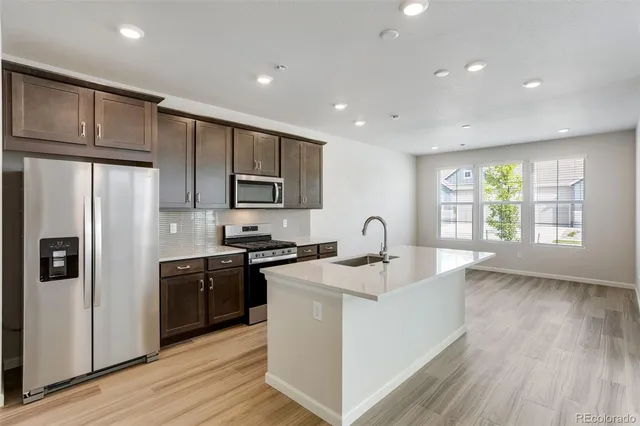 a kitchen with granite countertop a sink and wooden floor