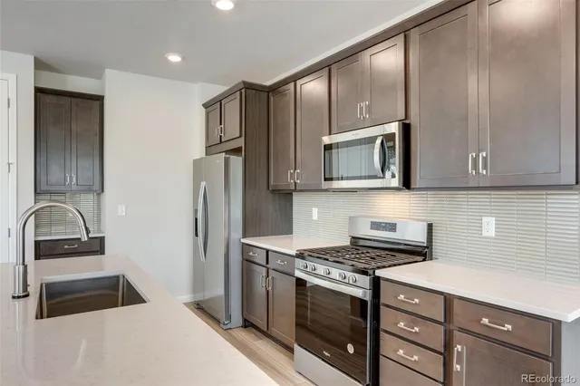 a kitchen with stainless steel appliances granite countertop a stove and a microwave