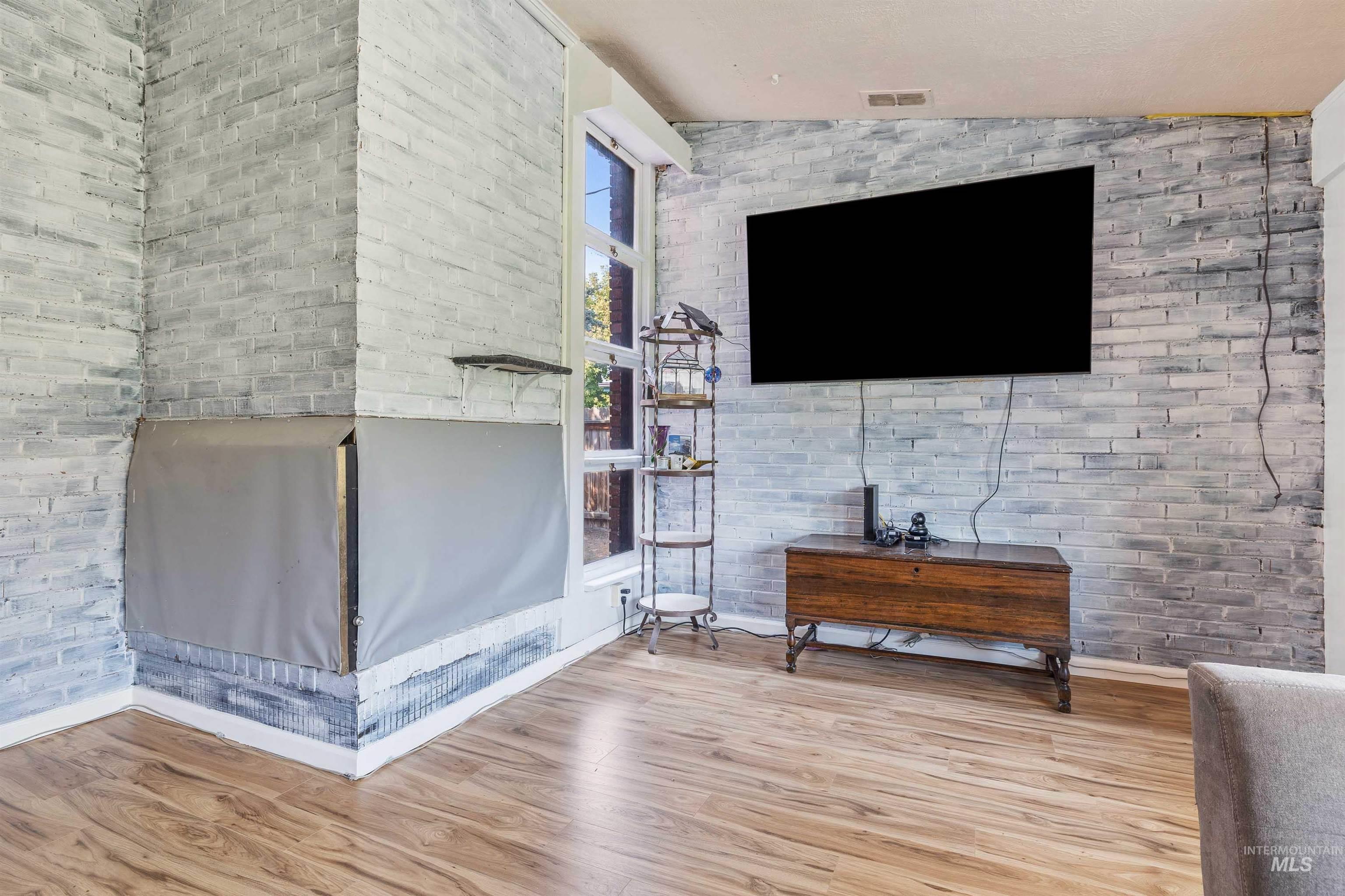 817 Union Avenue Filer, ID 83328 - Photo 6 of 37 Living area featuring brick wall, light wood finished floors, and vaulted ceiling