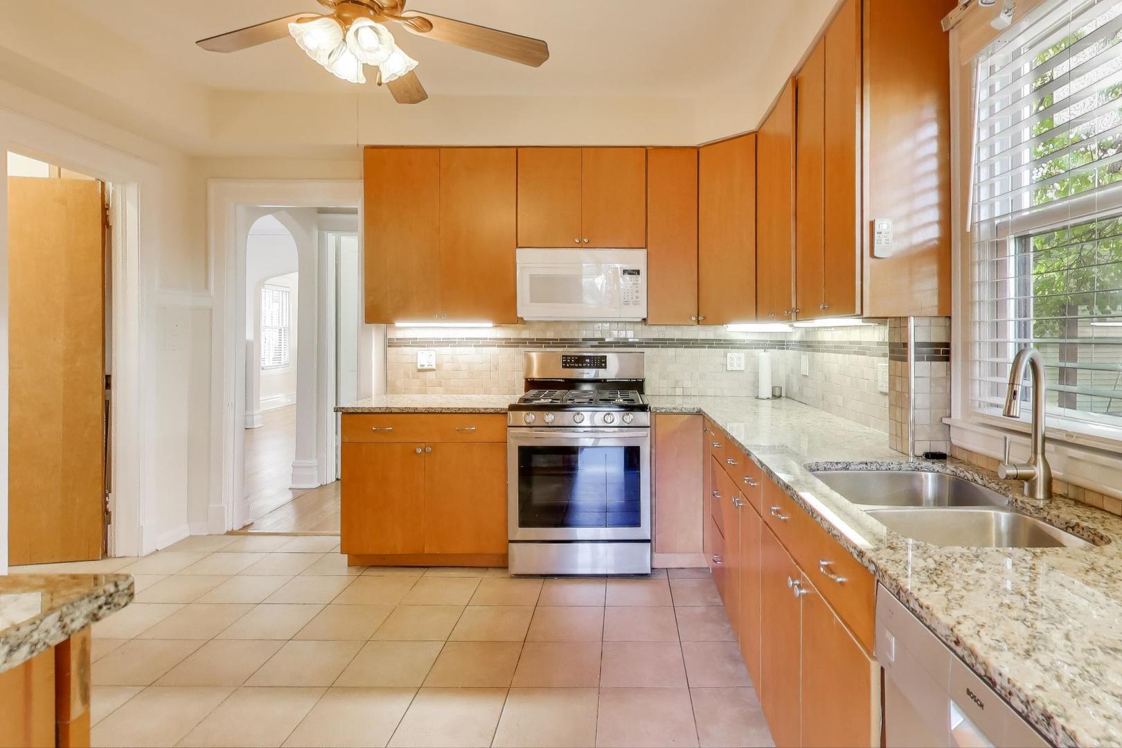 916 Pleasant Street, Unit 1 Oak Park, IL 60302 - Photo 11 of 23 a kitchen with stainless steel appliances granite countertop a stove a sink and a microwave