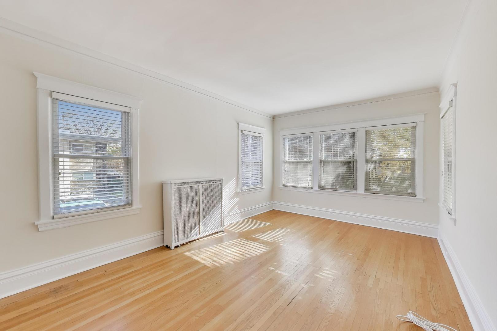 916 Pleasant Street, Unit 1 Oak Park, IL 60302 - Photo 5 of 23 an empty room with wooden floor and windows