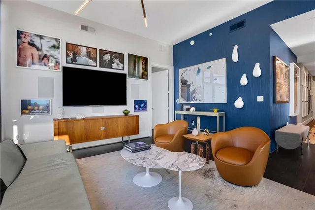 a living room with furniture a rug and a lamp