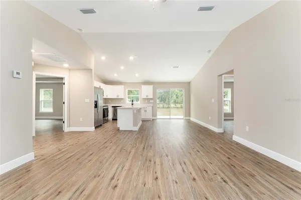a view of a big room with wooden floor and windows