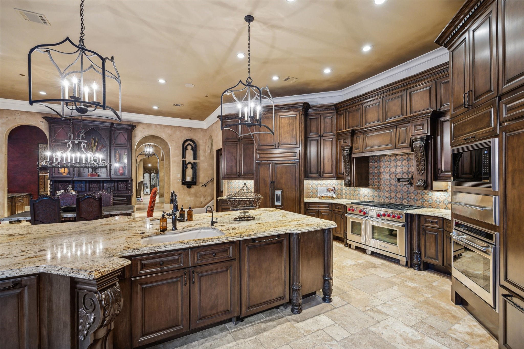 11095 Memorial Drive Houston, TX 77024 - Photo 11 of 48 a large kitchen with granite countertop a large stove a sink dishwasher a dining table and chairs with wooden floor