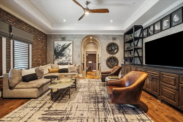 a living room with furniture a chandelier and a flat screen tv