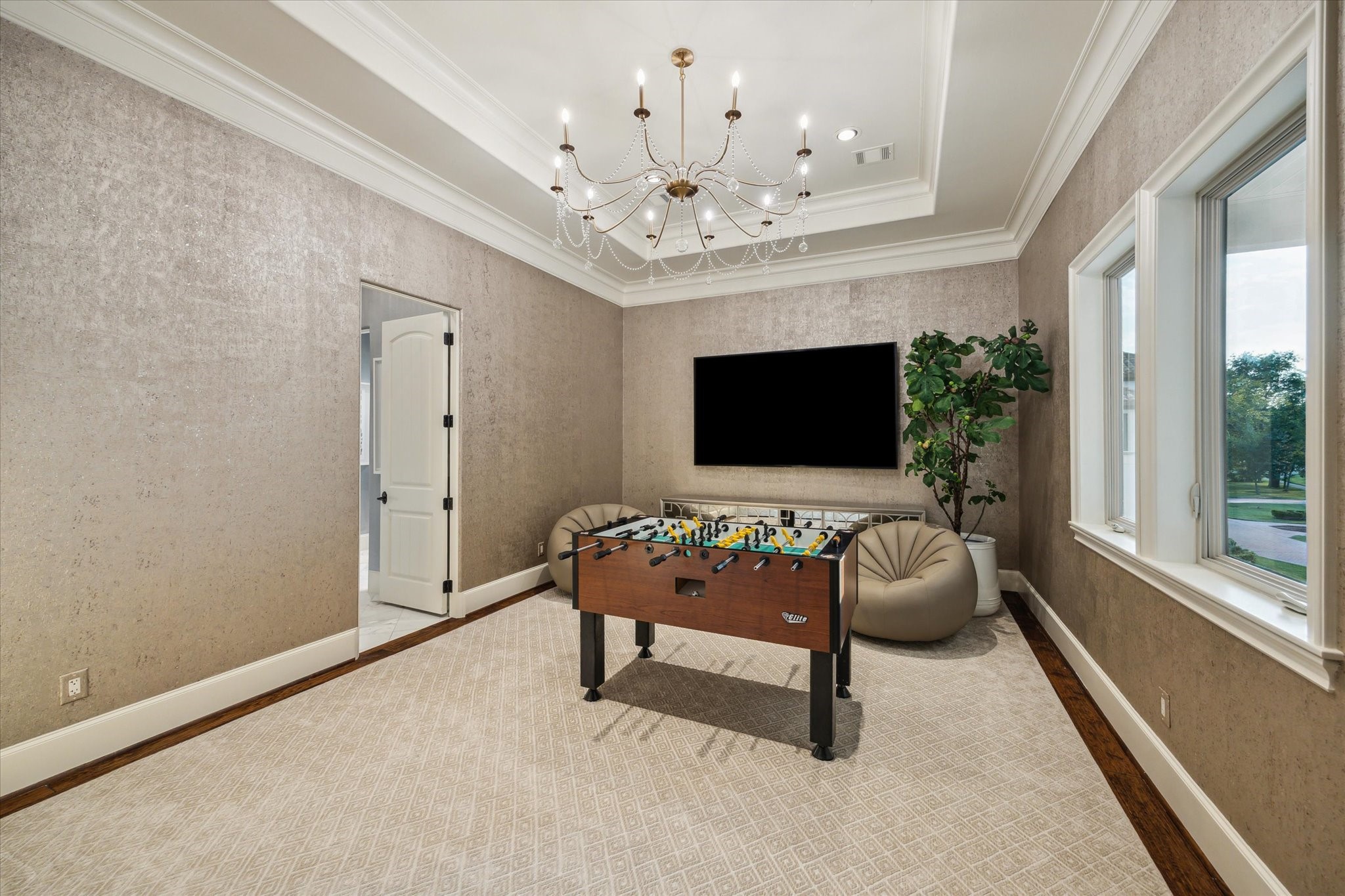 11095 Memorial Drive Houston, TX 77024 - Photo 27 of 48 a living room with furniture a chandelier and a flat screen tv
