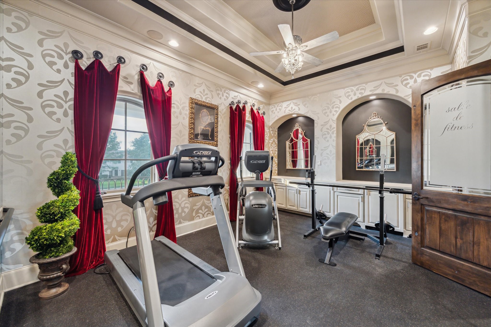 11095 Memorial Drive Houston, TX 77024 - Photo 28 of 48 The exercise room features rubber flooring, 2 floor-to-ceiling mirrors and a wall-mounted barre handrail. Textured paisley wallpaper framed by two arched casement windows with custom red velvet draperies adds a theme of elegance.
