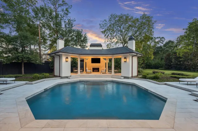 a front view of a house with yard swimming pool and outdoor seating