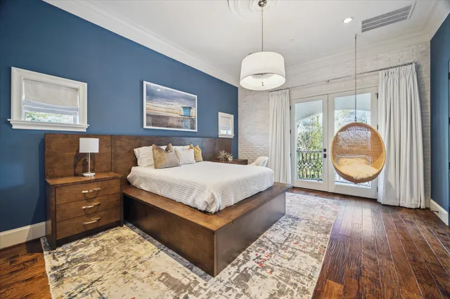 a spacious bedroom with a bed a couch and chandelier