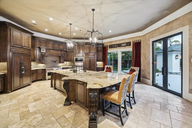 a kitchen with kitchen island a dining table chairs sink and cabinets