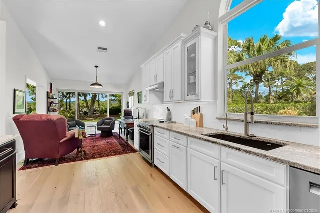 a kitchen with stainless steel appliances granite countertop a coffee maker a sink a counter space and cabinets