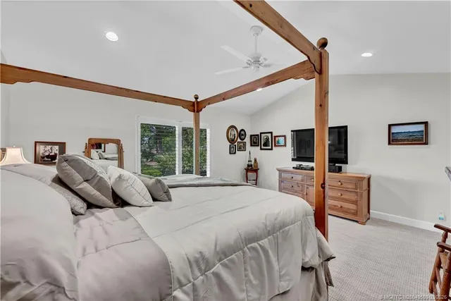 a bedroom with a large bed and a flat tv screen on dresser