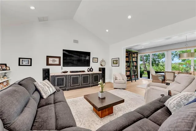 a living room with furniture a flat screen tv and a large window