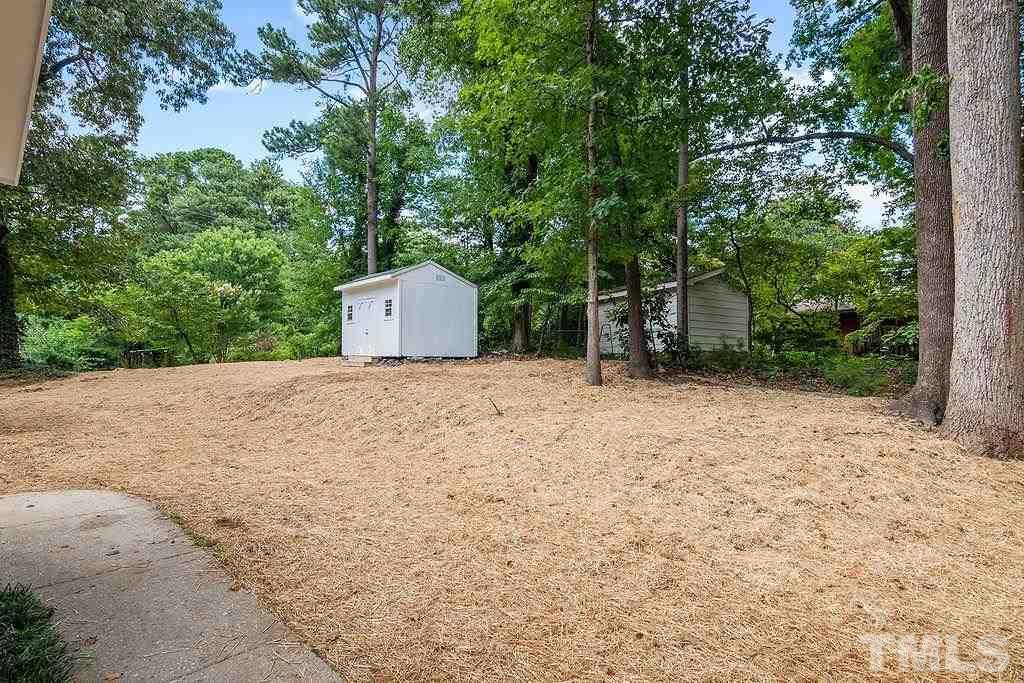 4408 Pamlico Drive Raleigh, NC 27609 - Photo 18 of 20 a backyard of a house with large trees and plants