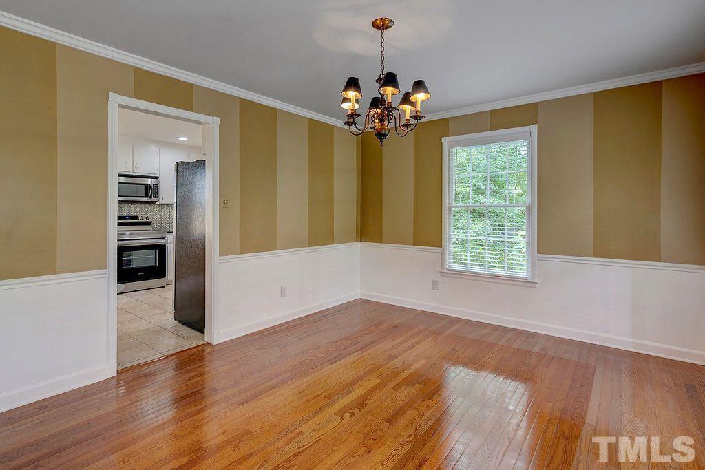 4408 Pamlico Drive Raleigh, NC 27609 - Photo 5 of 20 a view of a livingroom with a chandelier fan and wooden floor