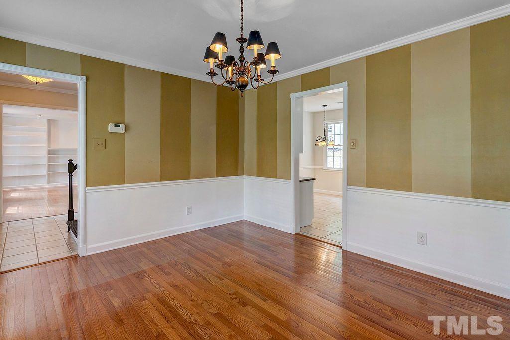4408 Pamlico Drive Raleigh, NC 27609 - Photo 6 of 20 a view of a livingroom with wooden floor and a chandelier