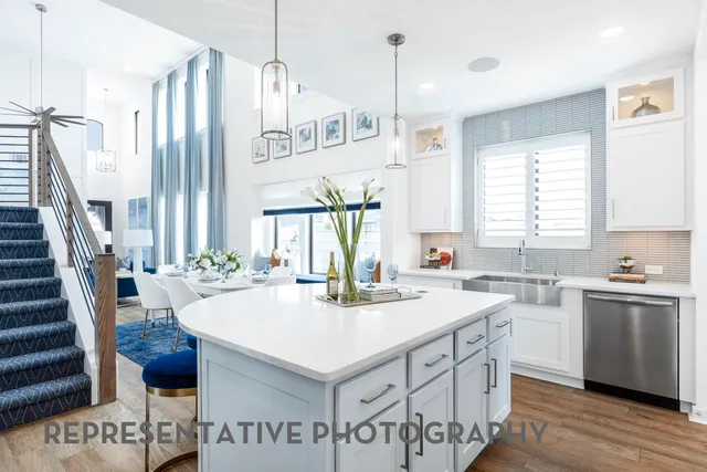 a kitchen with stainless steel appliances a sink a stove a refrigerator and island