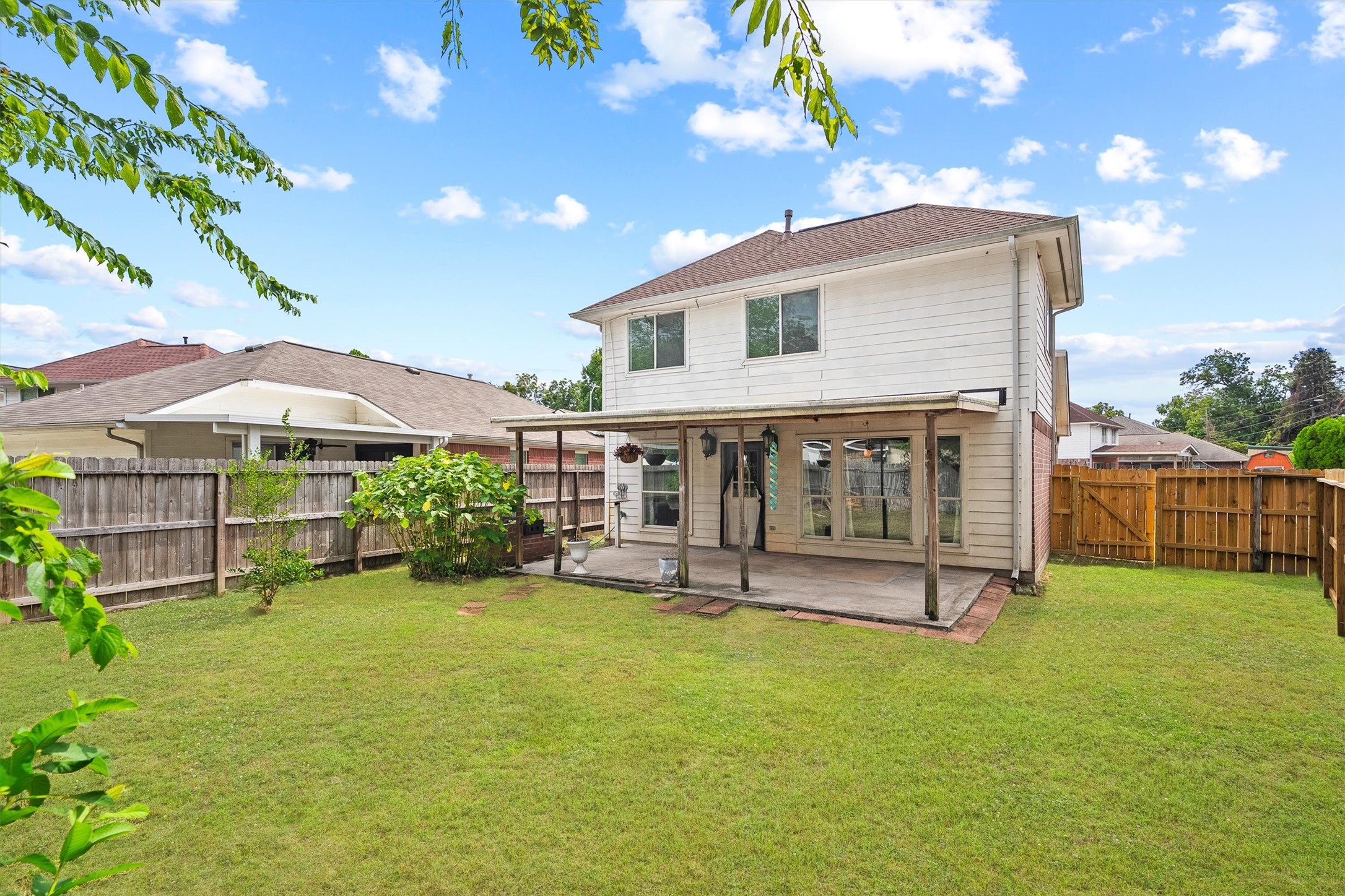 5426 Bourgeois Road Houston, TX 77066 - Photo 22 of 43 Spacious backyard with a covered patio, perfect for outdoor gatherings, surrounded by a wooden fence for privacy.