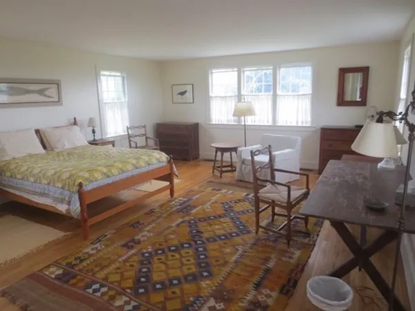 a spacious bedroom with a bed a table and chair