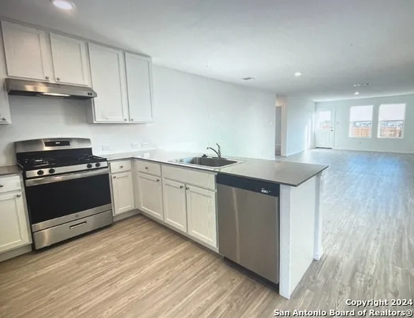 a kitchen with granite countertop a sink stainless steel appliances and cabinets