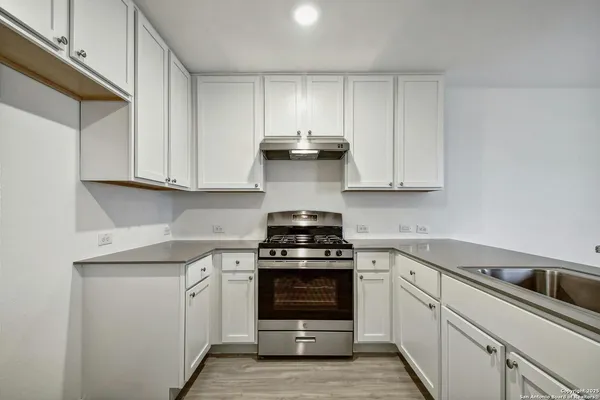 a kitchen with white cabinets and stainless steel appliances