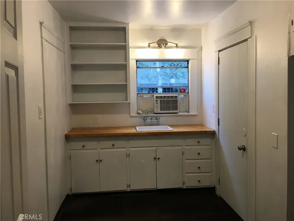an empty room with wooden floor fireplace and windows