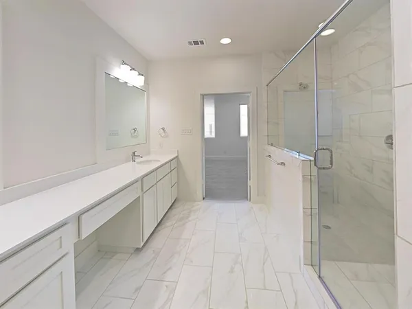 a bathroom with a double vanity sink a toilet and shower
