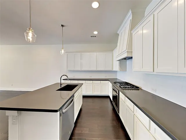 a kitchen that has a lot of cabinets and wooden floor