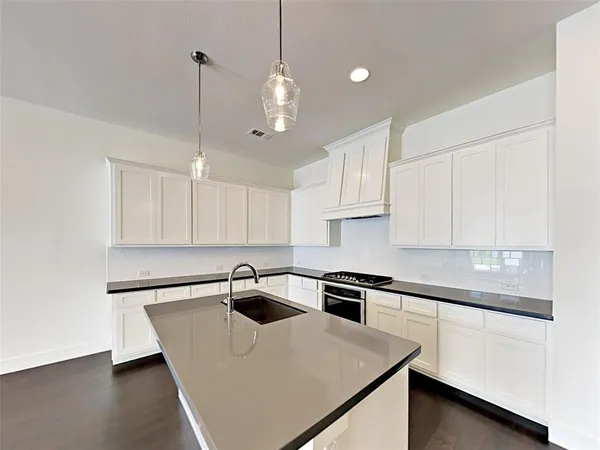 a kitchen with a sink a stove and cabinets
