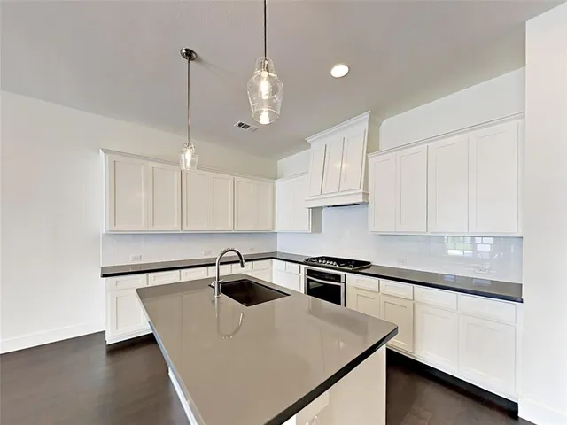 a kitchen with a sink a stove and cabinets