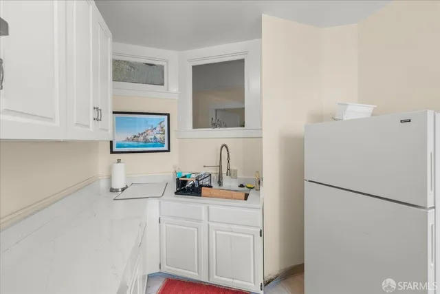 a view of a hallway with wooden floor and a bathroom