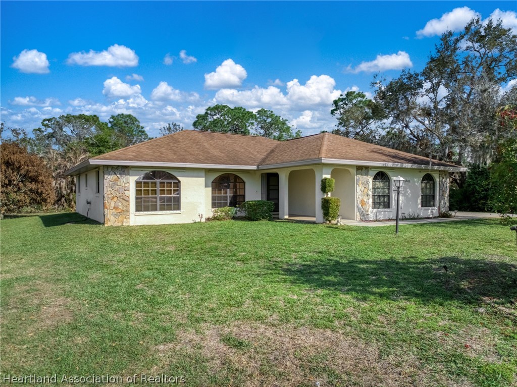 5802 Golden Road Sebring, FL 33875 - Photo 3 of 37 a front view of a house with a garden
