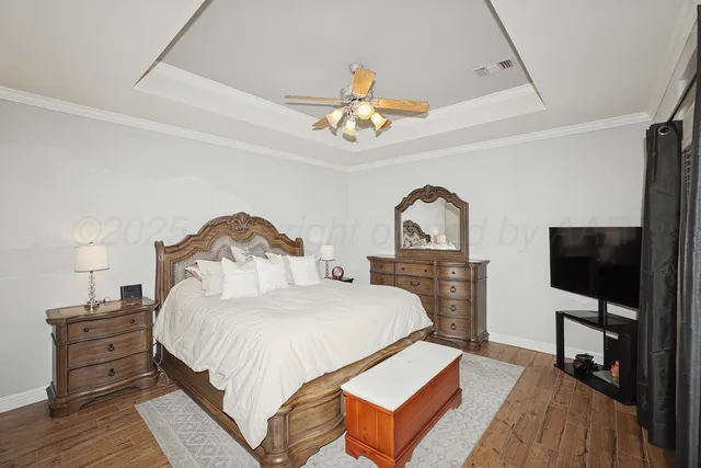 a bedroom with a bed and a flat tv screen on dresser