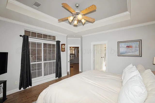 a bedroom with a large bed and a chandelier