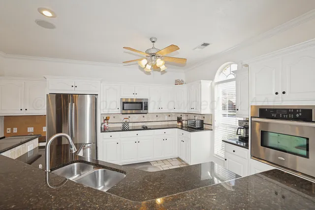 a kitchen with a sink a stove and cabinets