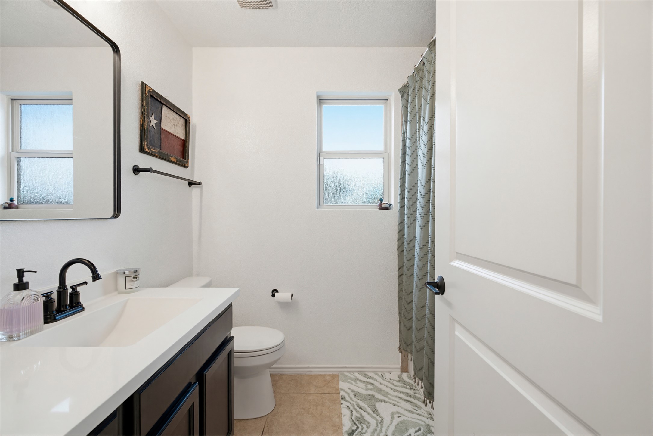 5705 Southerner Way Austin, TX 78747 - Photo 13 of 22 A well-lit lavatory features a contemporary vanity and ample natural illumination.