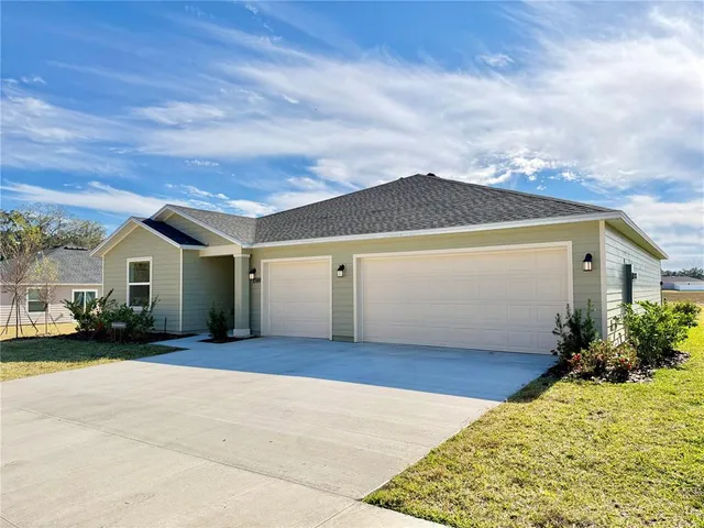 a front view of house with yard and trees in the background