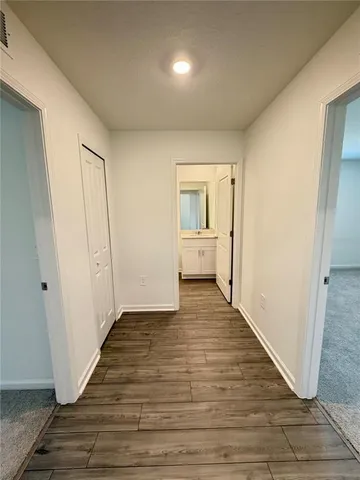 a view of a hallway with wooden floor