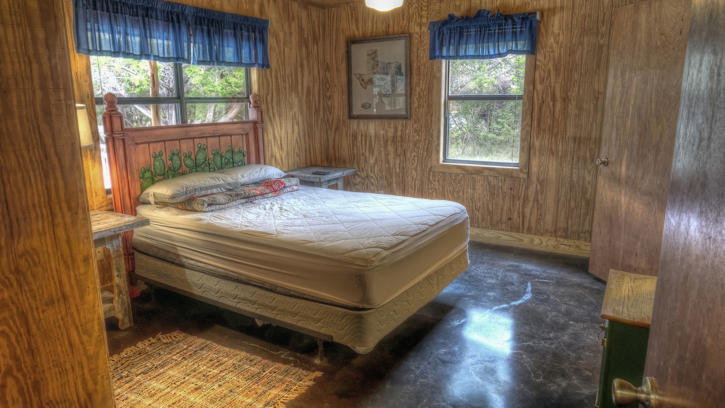 170 Cedar Lane Concan, TX 78838 - Photo 11 of 18 a bed sitting in a bedroom next to a window