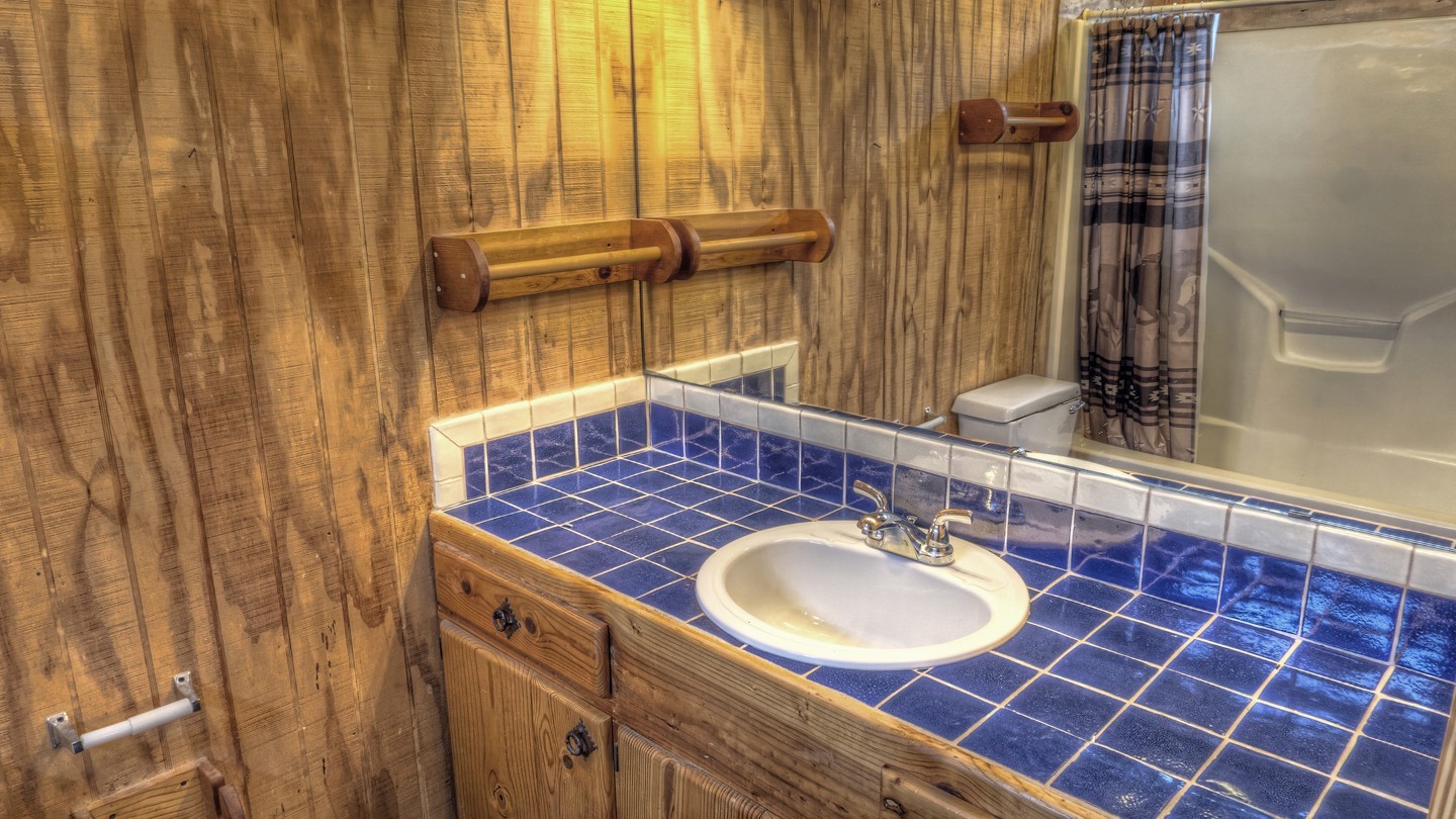 170 Cedar Lane Concan, TX 78838 - Photo 12 of 18 a bathroom with a sink a mirror and a shower curtain