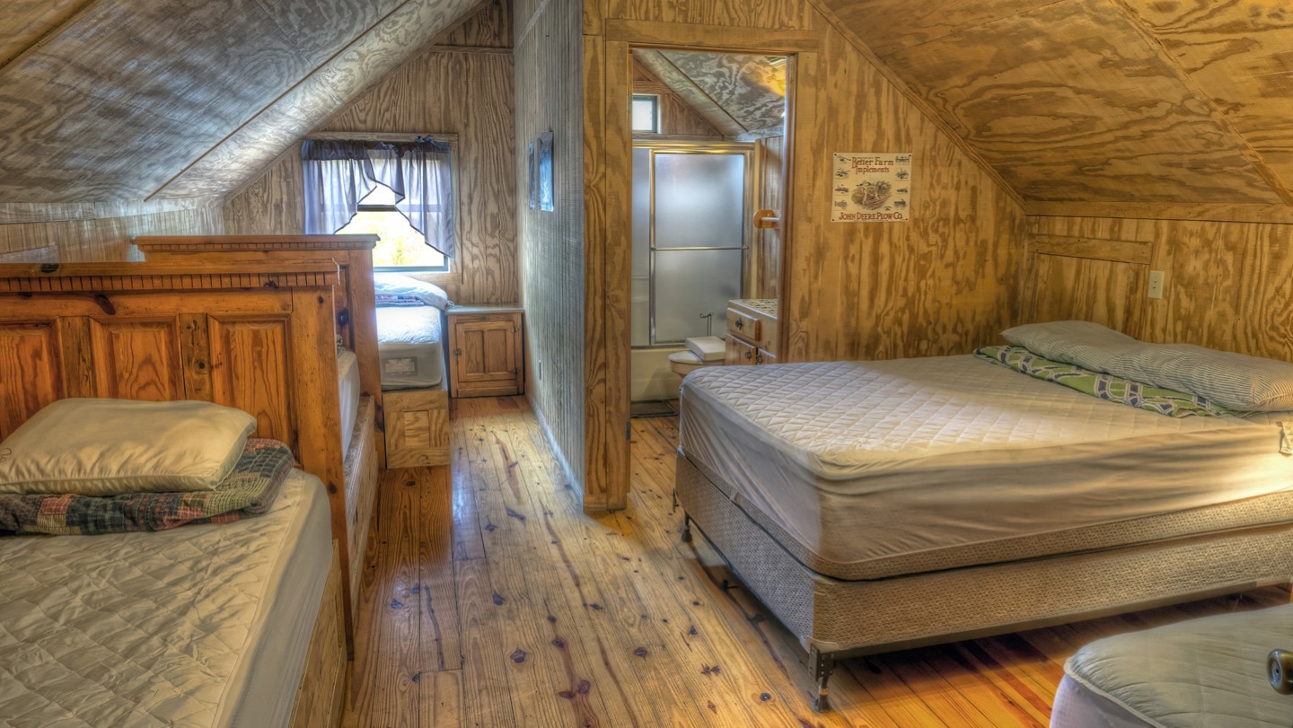 170 Cedar Lane Concan, TX 78838 - Photo 13 of 18 a bedroom with a bed and wooden floor