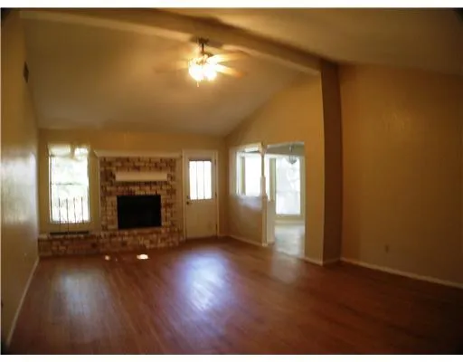 a view of an empty room with a fireplace and a window