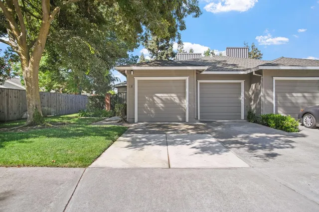 a front view of a house with a garden and yard